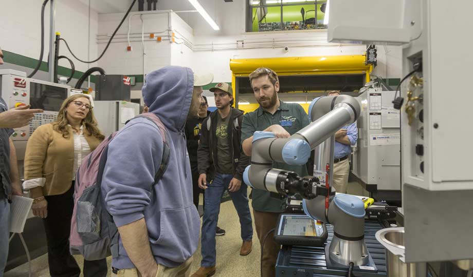 a student and instructor look at a machine during the TEC Spotlight
