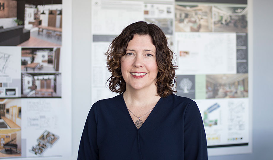 Shelly Mocchi smiling infront of interior design work in hallway