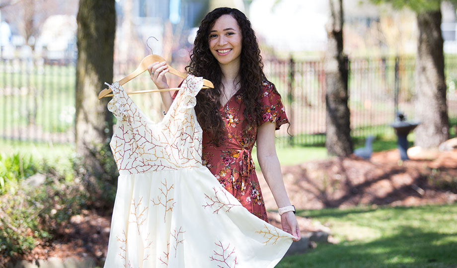 Aby Cardenas Arcila holding a dress she designed