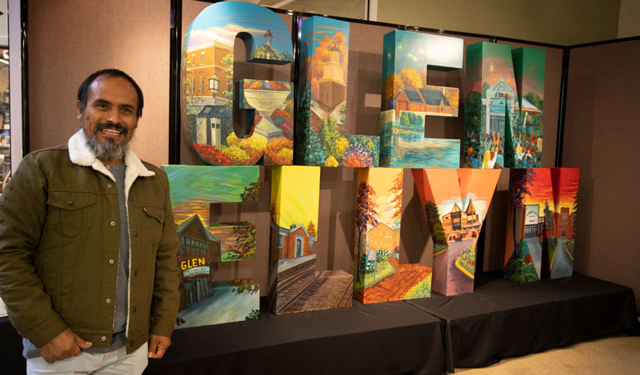 Mexican artist and muralist Juan Chawuk stands next to his letters display