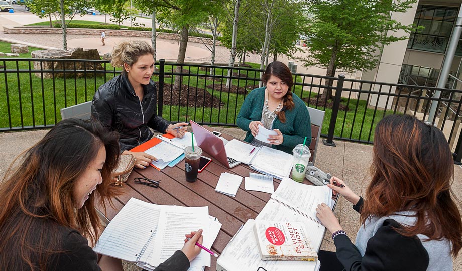 Students outside at a table studying
