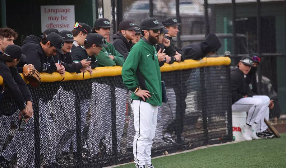 Pat Leahy standing on sidelines with baseball team.