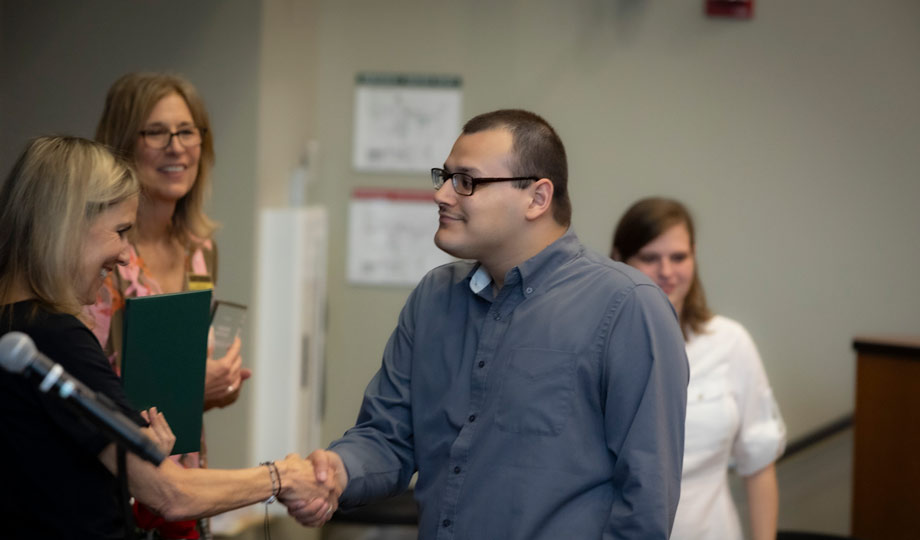 COACH graduate accepting their certificate