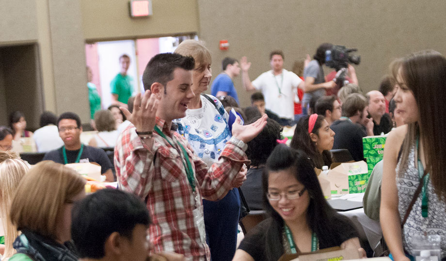 students talk while seated at a table